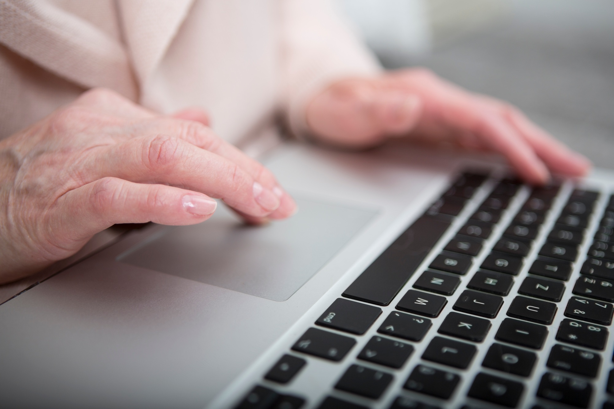 Senior woman using laptop touchpad